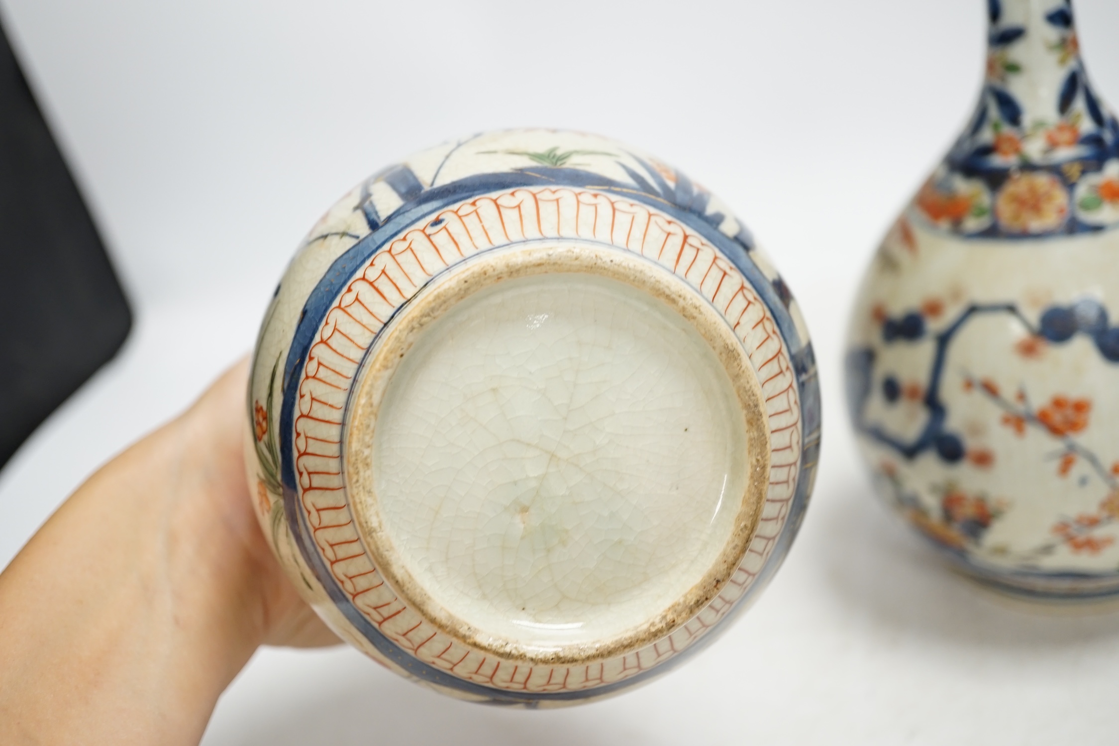 A pair of Japanese Arita bottle vases, c.1700, 24cm. Condition - heavily crazed, one with small section of neck broken and reglued